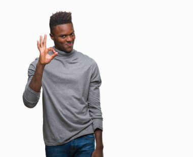 Gülümseyen izole arka plan üzerinde genç Afro-Amerikan adam el ve parmaklar ok işaretiyle yapıyor olumlu. Başarılı ifade.