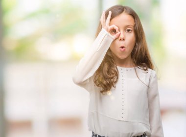 Esmer Latin kız ok jest yapıyor sürpriz yüz, göz parmaklarının arasından seyir ile şok. İmansız ifade.