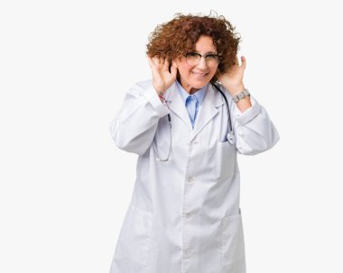 Orta ager kıdemli doktor kadın her iki kulak jest, dedikodu için meraklı ellerde dinliyoruz izole arka plan yüzünden. İşitme sorunu, sağır
