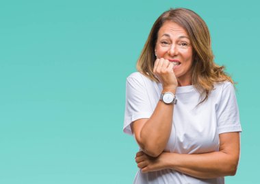 Orta yaş üst düzey İspanyol kadın yüzünden stresli ve gergin ile izole arka plan tırnak ısırma dudaklarından eller. Anksiyete sorunu.