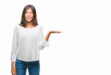 Neşeli sunulması ve kameraya bakarak avucunun ile işaret gülümseyen izole arka plan üzerinde Genç Asyalı kadın.