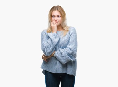 Stresli ve gergin elle çivi ısırma ağzına bakarak izole arka plan üzerinde kış kazak giyen genç beyaz kadın. Anksiyete sorunu.