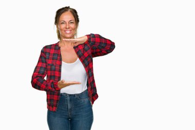 İzole arka plan eller eller büyük gösterilen ve büyük boy işareti, ölçü birimi sembolü ile üzerinde rahat ceket giyen orta yaş yetişkin kadın. Kameraya bakarak gülümsüyordu. Ölçüm kavramı.