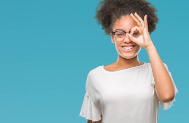 Genç afro Amerikalı kadın gülümsüyor, parmakları ile mutlu yüz üzerinden seyir göz el ile ok jest yapıyor izole arka plan üzerinde gözlük.