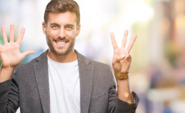 Genç yakışıklı iş adamı gösterilen ve parmakları ile işaret izole arka plan üzerinde kendinden emin ve mutlu gülümseyerek süre sekiz numara.