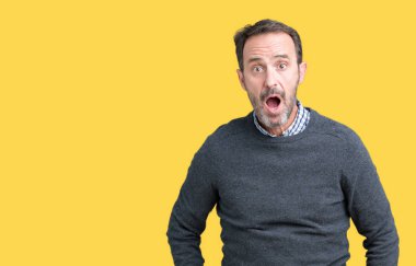 Yakışıklı orta yaş komuta sizde izole arka plan korkuyor ve şok sürpriz ifade, korku ve heyecan yüz üzerinden bir kazak giyiyor.