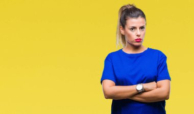 Yüzünde ciddi bir ifade ile izole arka plan üzerinde rahat mavi t-shirt giyen genç güzel kadın. Basit ve doğal kameraya bakıyor.