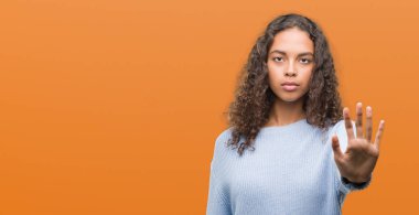 Güzel genç İspanyol kadın açık eliyle dur işareti ile ciddi ve kendine güvenen ifade, savunma hareketi yapıyor