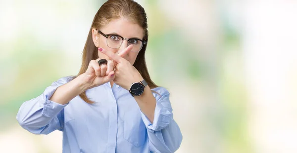 美丽的中年成熟的女商人戴眼镜在孤立的背景拒绝表达交叉手指做负号 — 图库照片