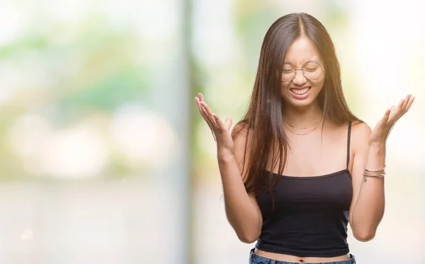 若いアジアの女性は狂牛病と悲鳴上げられたとクローズの目が興奮して腕の成功のために狂気を祝う孤立の背景にメガネを着用します 勝者の概念 — ストック写真