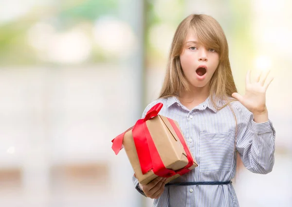 若い金髪の幼児叫んで笑顔で勝利を祝ってと手を上げた現在非常に幸せと興奮 受賞式を開催 — ストック写真