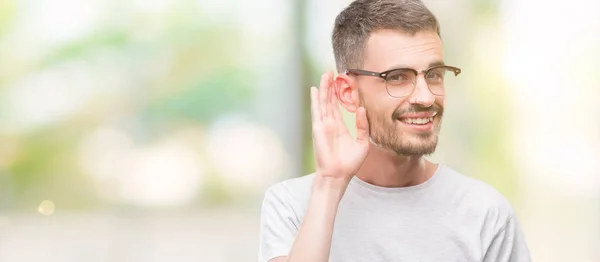 Joven Hombre Adulto Tatuado Sonriendo Con Mano Sobre Oído Escuchando —  Fotos de Stock