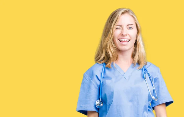 Hermosa Joven Doctora Con Uniforme Médico Sobre Fondo Aislado Guiñando —  Fotos de Stock