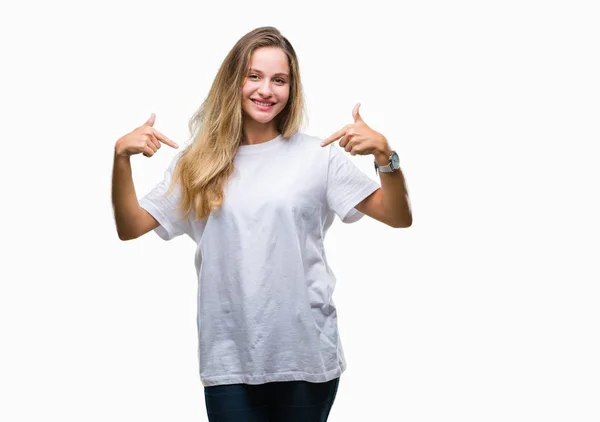 年轻美丽的金发女子穿着休闲白色 T恤在孤立的背景看起来自信与微笑在脸上 指着自己与手指自豪和快乐 — 图库照片