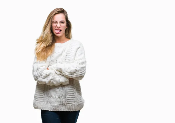 年轻美丽的金发碧眼的女人穿着冬天的毛衣和太阳镜在孤立的背景伸出舌头出来高兴与有趣的表情 情感概念 — 图库照片