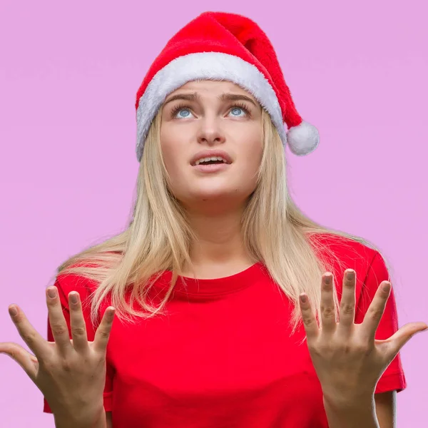 若い白人女性をクリスマスの帽子をかぶって狂気の背景を分離し 怒って叫んで 叫んで積極的な表現と腕を上げます 欲求不満のコンセプト — ストック写真