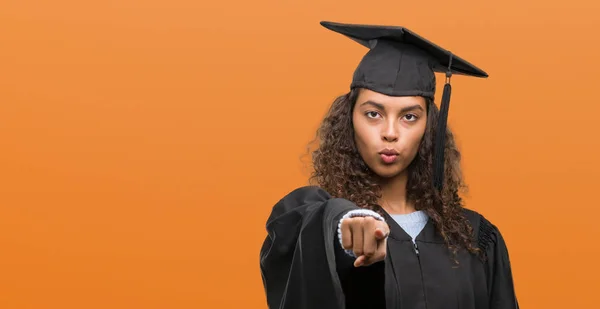 若いヒスパニック女性カメラと指で指している制服着て卒業手に署名 正面からポジティブで自信のジェスチャー — ストック写真
