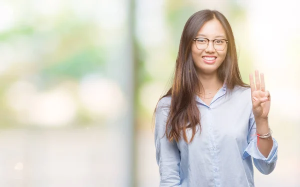 若いアジア ビジネス女性が孤立した背景表示と指で上向きに眼鏡をかけて番号を自信を持って 幸せな笑みを浮かべている間 — ストック写真