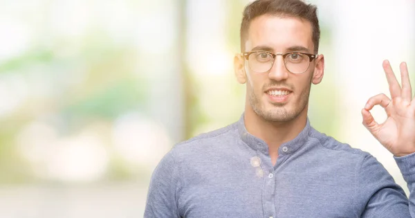 Pemuda Tampan Elegan Memakai Kacamata Tersenyum Positif Melakukan Tanda Dengan — Stok Foto