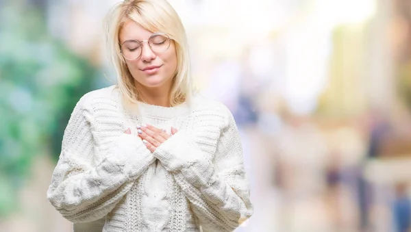 年轻漂亮的金发女人穿着冬季毛衣和眼镜在孤立的背景微笑着双手在胸前闭上眼睛和感激的手势脸上 健康理念 — 图库照片