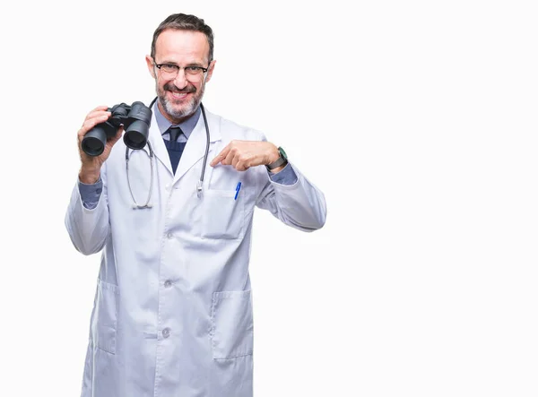 中年高级医生男子通过双筒望远镜查出的背景与惊讶的脸指向自己的手指 — 图库照片