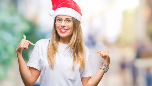 若くてきれいな女性の顔に笑顔と自信を持って 誇りと幸せな指で自分を指している孤立した背景にクリスマスの帽子をかぶって — ストック写真