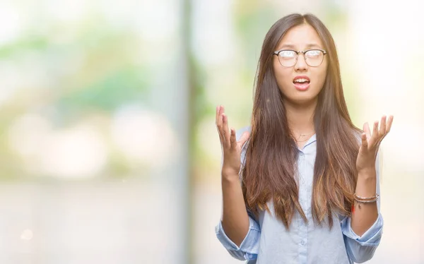 年轻的亚洲商业妇女戴着眼镜在孤立的背景下疯狂和疯狂的呼喊和激烈的表达和武器大声喊叫 挫折概念 — 图库照片