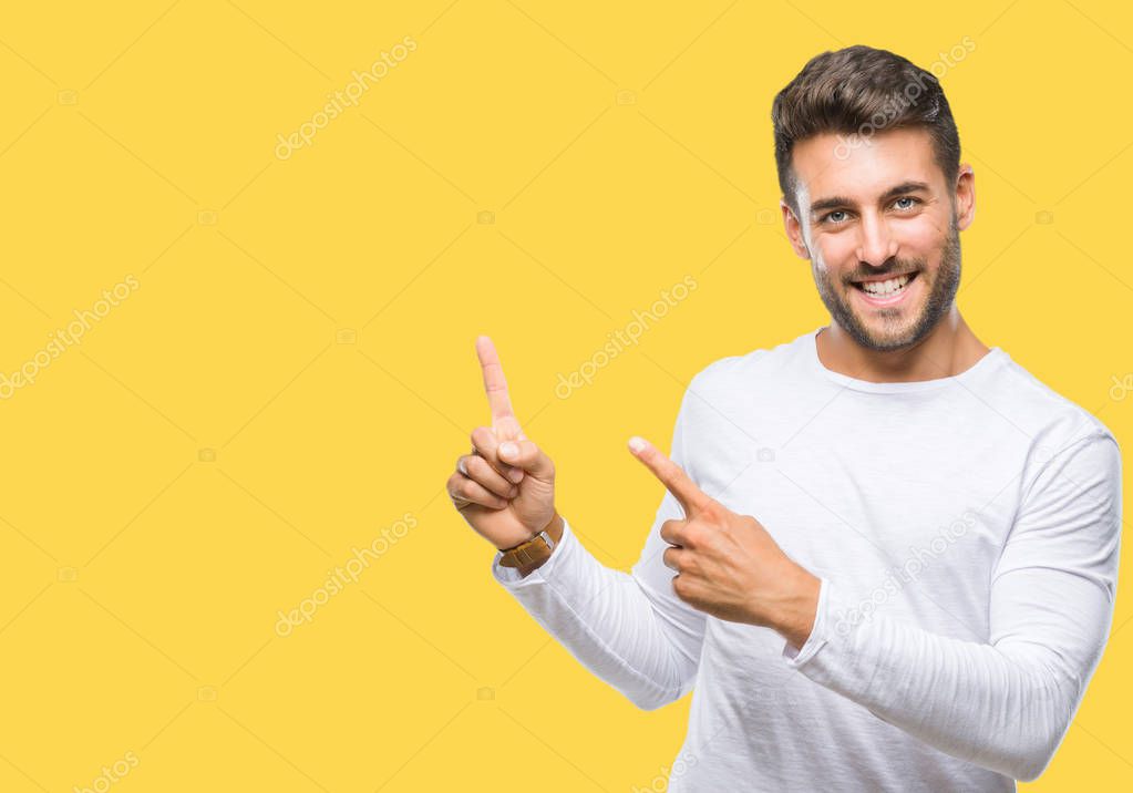 Young handsome man over isolated background smiling and looking at the camera pointing with two hands and fingers to the side.