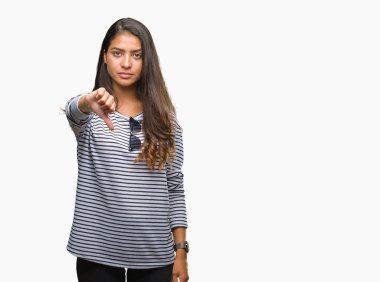 Genç güzel Arap kadın mutsuz ve kızgın ret gösterilen ve başparmak aşağı hareketi ile negatif seyir izole arka plan üzerinde güneş gözlüğü takıyor. Kötü ifade.