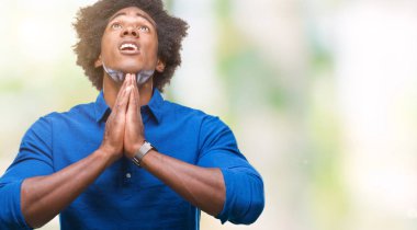 Yalvarıyor ve umut ifade yüzünde çok duygusal ve endişe ile birlikte elleriyle dua izole arka plan üzerinde Afro Amerikalı adam. Bağışlanmak. Din kavramı.