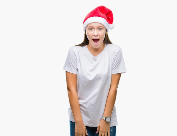 驚きの表現 恐怖と興奮した顔でショックを受けて孤立した背景にクリスマスの帽子をかぶって若い美しい白人女性 — ストック写真