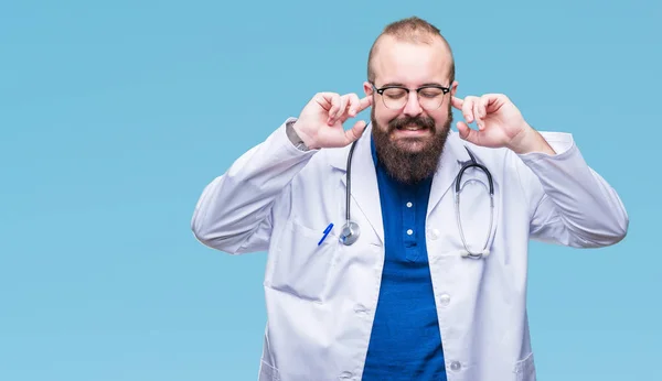 年轻的高加索医生人穿着医疗白色外套在孤立的背景覆盖耳朵用手指与恼火的表示为大声的音乐的噪声 聋哑人的概念 — 图库照片