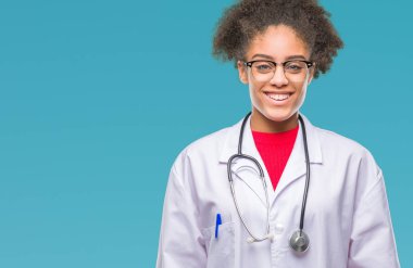 Genç afro Amerikalı doktor kadın yüzünde mutlu ve güzel bir gülümseme ile izole arka plan yüzünden. Şanslı kişi.