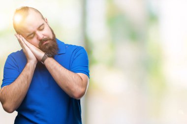 Uyku yorgun hayal ve ile gülümseyen gözleri kapalı iken ellerle birlikte poz izole arka plan üzerinde mavi gömlek giymiş genç beyaz hipster adam.