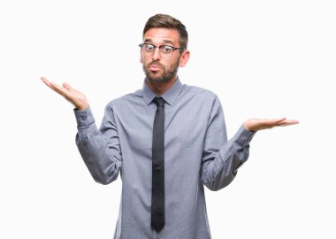Genç yakışıklı iş adamı izole arka plan clueless ve şaşkın bir ifadeyle kollar ve eller ortaya çıkar üzerinden. Şüphe kavramı.