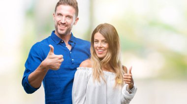 Genç çift hareketi el ile mutlu yaşasın yapıyor izole arka plan üzerinde aşık. Kameraya bakarak başarı gösteren ile ifade onaylama.