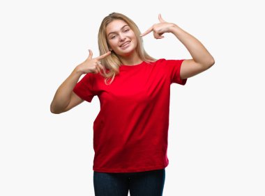 Kendinden emin gösterilen ve işaret parmakları diş ve ağız ile gülümseyen izole arka plan üzerinde beyaz kadın. Sağlık kavramı.