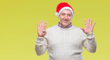 Üst düzey yakışıklı Noel şapka üzerinde gösterilen arka plan izole ve parmakları ile işaret numara 9 kendinden emin ve mutlu gülümseyerek süre.