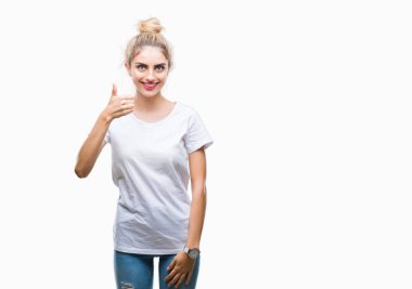 Hareketi el ile mutlu yaşasın yapıyor izole arka plan üzerinde beyaz t-shirt giyen genç güzel sarışın bir kadın. Kameraya bakarak başarı gösteren ile ifade onaylama.
