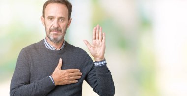 Yakışıklı orta yaş komuta sizde üzerinde bir kazak giyen izole arka plan göğüs ve bir sadakat sözü yemin yapma avuç, el ile küfür