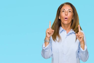 Güzel orta yaş iş yetişkin kadın izole arka plan üzerinden hayran ve yukarıya bakıp parmakları ile işaret şaşırttı ve silah kaldırdı.