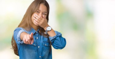 Mavi kot gömlek izole üzerinde giyen genç güzel esmer kadın arka plan sizin parmak el kamerasıyla ağzına, utanç ifadesi işaret eden gülme