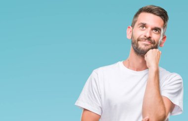 Yakışıklı delikanlı çene düşünme hakkında soru, dalgın ifade üzerine el ile izole arka plan üzerinde. Düşünceli yüzüyle gülümsüyor. Şüphe kavramı.