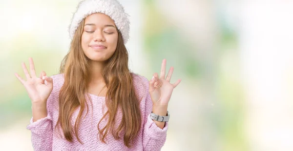 年轻美丽的黑发女人穿着毛衣和冬季帽子在孤立的背景放松和微笑与眼睛闭着做冥想手势用手指 瑜伽概念 — 图库照片