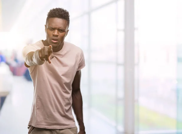 Young african american man pointing with finger to the camera and to you, hand sign, positive and confident gesture from the front