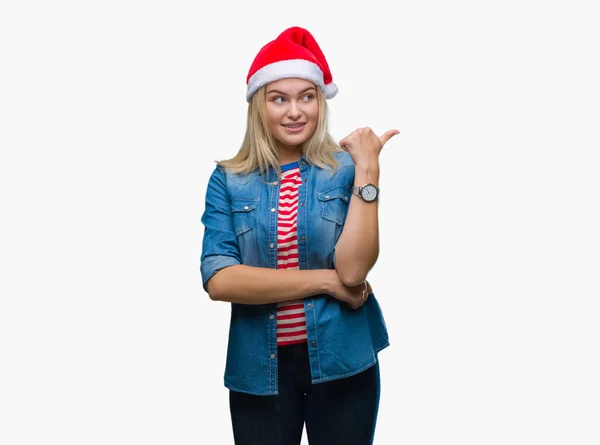 探していると親指側に上向きの幸せそうな顔を浮かべて隔離された背景にクリスマスの帽子をかぶって若い白人女性 — ストック写真