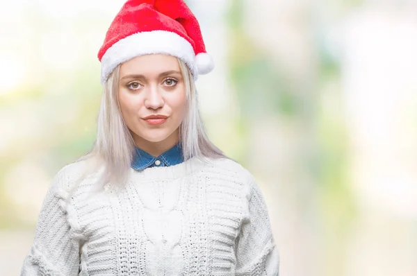 年轻的金发女子戴着圣诞节帽子在孤立的背景与严肃的表情在脸上 简单自然地看着相机 — 图库照片