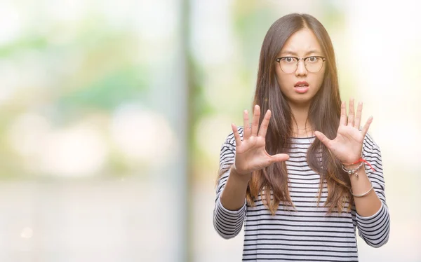 年轻的亚洲妇女戴着眼镜在孤立的背景下害怕和恐惧的表情用手停止手势 震惊地大叫 恐慌概念 — 图库照片