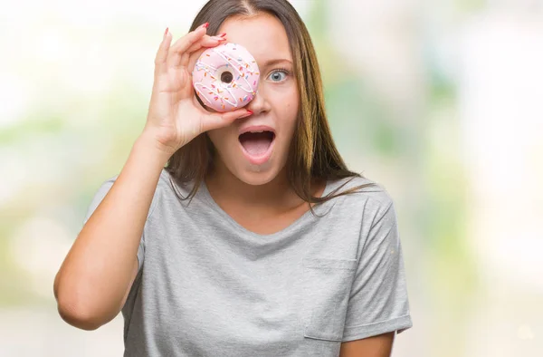 孤立した背景驚き顔 恐怖表現と興奮とショックで怖いに甘いドーナツを食べる若い白人女性 — ストック写真