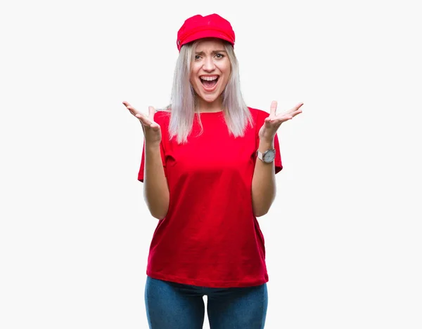 年轻的金发女子戴着红帽在孤立的背景庆祝疯狂和疯狂的成功与胳膊举起和闭上眼睛尖叫兴奋 获奖者概念 — 图库照片